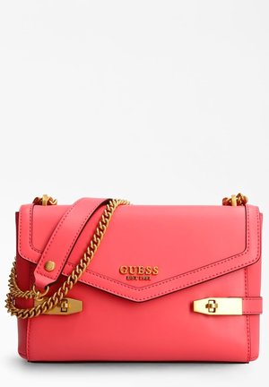 Sac à main GUESS rose avec bandoulière chaîne dorée, logo doré et détails de fermoir dorés sur fond blanc immaculé.