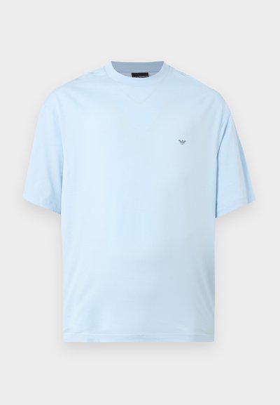 Ανοιχτό μπλε κοντομάνικο T-shirt με στρογγυλή λαιμόκοψη και μικρό μαύρο λογότυπο στο αριστερό στήθος, απεικονισμένο σε απλό λευκό φόντο.