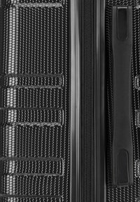 Zwarte harde koffer met een gestructureerd hexagonaal patroon, dubbele rits en een stevige zijhandgreep voor een goede grip en transport.