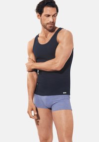 Dark navy tank top made of smooth fabric, paired with light blue boxer briefs. The tank features a rounded neckline and fitted design.