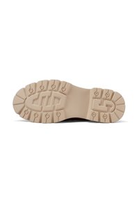 Suola di scarpa in gomma beige con scanalature profonde e forma arrotondata. Presenta un logo in rilievo e piccoli chiodi circolari per la trazione.