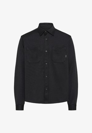 Mustast pikkade varrukatega särk-jakk, millel on terav krae, eest trukid ja kaks rinnataskut, valgel taustal.