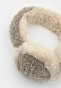 Öronmuffar i beige och ljusbrun fuskpäls med en mjuk yta och rundad form för värme och komfort. Mjuk textur hela vägen.