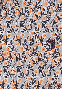 Bloemendessin in zacht grijs met oranje en donker marineblauwe bloemen en bladeren. Bevat een lichtoranje knoop en geborduurd logo-detail.