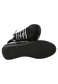 Svarta mocka- och läderskor med vita snören, som har en strukturerad svart gummisula och "CANDICE COOPER"-logotyp på sidan.