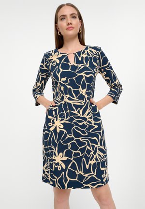 Vestido de color navy con patrón floral beige, mangas tres cuartos, detalle de escote con abertura y bolsillos laterales, hecho de una tela suave.