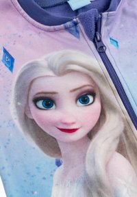 Tuta in felpa con una ritrattistica del personaggio con capelli biondo chiaro, occhi blu e uno sfondo rosa con motivi di cristalli di ghiaccio. Chiusura con cerniera.