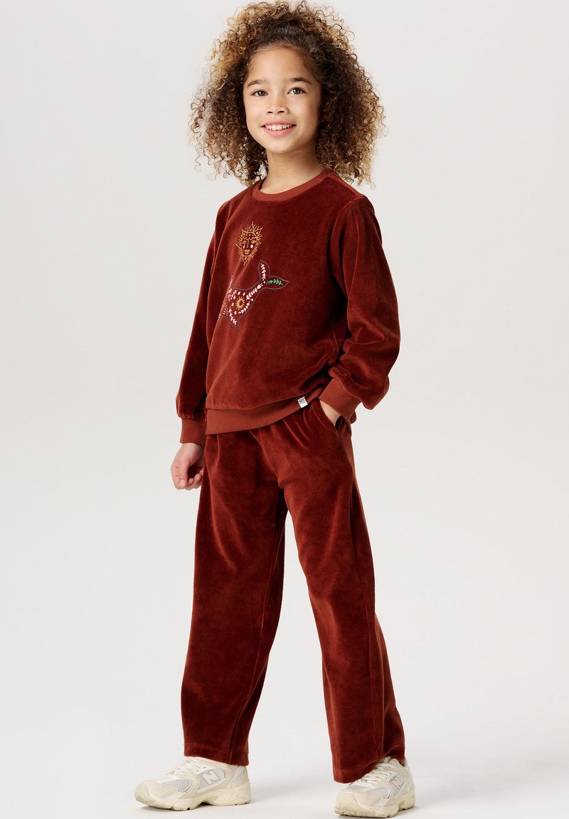 Rustfärgad velourtracksuit bestående av en sweatshirt med rund halsringning och broderad djurdesign, samt matchande byxor med elastiskt midjeband.