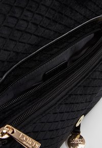 Borsa a tracolla nera trapuntata con superficie testurizzata, hardware in tonalità oro, compartimenti con doppia zip e una sola tracolla per il trasporto.