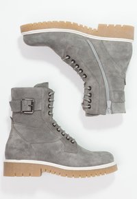 Harmaat mikrokuitujalkineet, joissa on teksturoitu paneeli, sivuvetoketju, nauhakiinnitys, solk yksityiskohta ja kumipohja, jossa on valkoinen reuna.