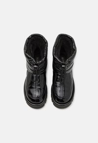 Black ankle boots with a shiny, textured finish, gathered collar, and drawstring detail. Thick sole with a rugged tread pattern.