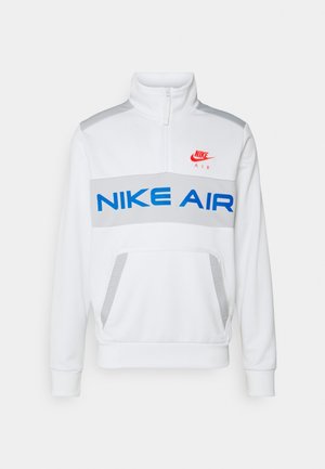 Weißer Nike Air Pullover mit Viertelreißverschluss, blau-grauem horizontalem Logoband, Kängurutasche und rotem Nike-Swoosh auf der Brust.