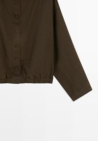 Braunes langärmliges Hemd mit Knopfleiste und elastischem Saum am unteren Rand, aus strukturiertem Stoff.