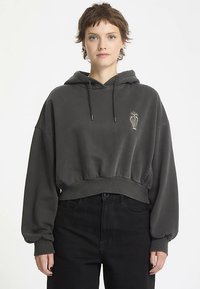 Grauer, kurz geschnittener Hoodie mit strukturierter Oberfläche und kleinem besticktem Muster. Verfügt über eine Kapuze mit Kordelzug und locker sitzende Ärmel.