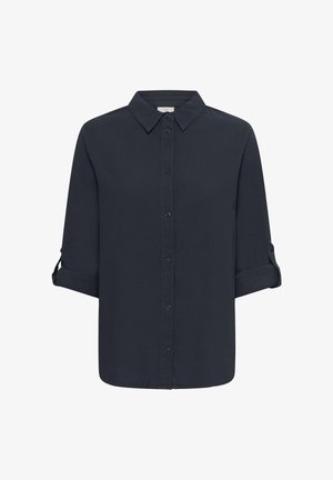 Svart langermet skjorte med knappestolpe foran, oppbrettede ermer festet med knappede stropper, og en spiss krage.