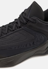 Sorte atletiske sneakers med et slankt design, tekstureret overflade og meshdetaljer. Blødt stof og en gummisål sikrer holdbarhed.