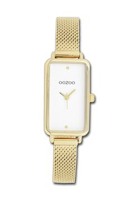 Montre rectangulaire en or avec un cadran blanc, présentant un design minimaliste, un bracelet en mailles et trois petits cadrans indiquant l'heure.