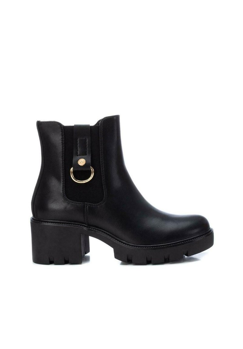 Schwarze Knöchelstiefel aus glattem Leder, mit einem klobigen Absatz und elastischen Seiteneinsätzen, versehen mit einem goldenen Ringakzent auf der Rückseite.