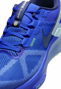 Sneaker Nike blu con tomaia in rete, superficie testurizzata, collettore imbottito e accenti grigi. Presenta una suola ammortizzata visibile etichettata "CK ZOOM".