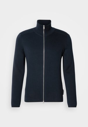 Dunkelblauer Reißverschluss-Pullover mit hohem Kragen. Aus geripptem Stoff, mit langen Ärmeln und einem silbernen Reißverschluss in der Mitte.