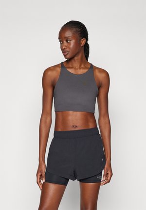 Schwarzes athletisches Croptop mit Rundhalsausschnitt, kombiniert mit schwarzen Shorts, die eine Innenauskleidung und ein minimalistisches Design aufweisen.