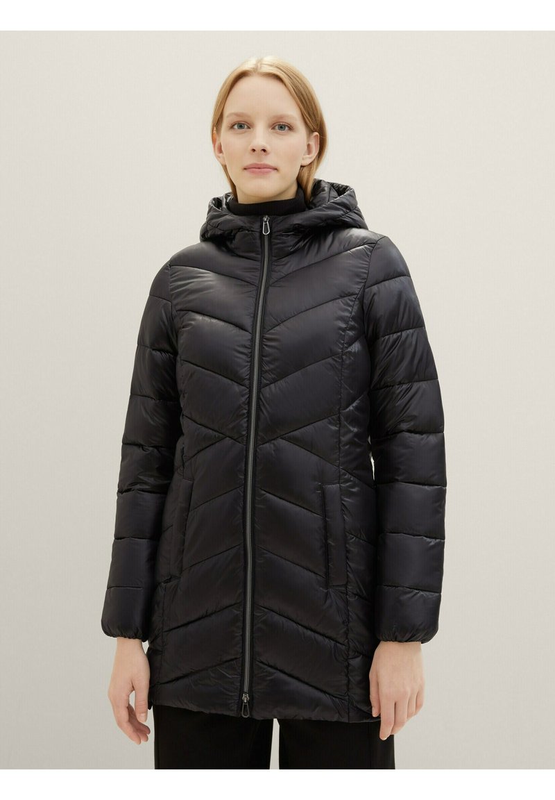 Giacca invernale nera e ovattata con zip frontale, cappuccio e motivo a chevron. Realizzata in un materiale liscio e lucido. Include tasche laterali.