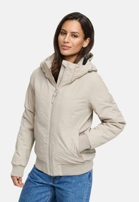Lichtbeige ritsjack met een capuchon, ribgebreide manchetten en onderrand, en zijzakken. Gladde textuur met een gestructureerd ontwerp.