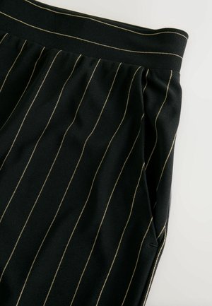 Musta kangashousut, joissa pystysuorat kultaiset ohuet raidat, joustava vyötärökaitale ja sivutaskut. Pehmeä tekstuuri ja räätälöity muotoilu.