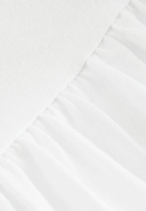 Tissu en coton blanc avec une partie supérieure lisse et un bas froncé texturé, présentant des variations subtiles de teinte et de texture.