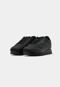 Pair of black athletic sneakers with laces and side zipper detail, shown from front side angle on a white background.