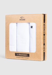 White boxershorts in a cardboard package with a transparent window. Box includes three shorts, labeled 'M.' Recyclable materials used.