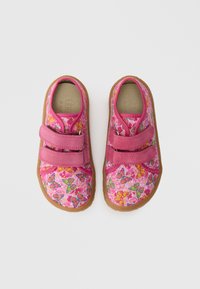 Pink fabric shoes with floral and butterfly patterns, featuring two Velcro straps and a brown rubber sole. Smooth texture and round shape.