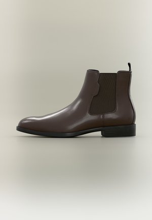 Botte Chelsea en cuir marron avec panneau latéral élastique, languette au talon, petit talon empilé et bout arrondi lisse, présenté de profil sur fond neutre.