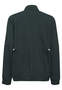 Chaqueta de color verde oscuro con mangas largas, puños elásticos y un dobladillo semicorto. Presenta acentos en negro y verde menta en la parte posterior.