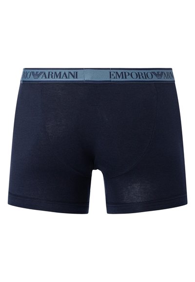 Navy blue cotton boxer shorts with a light blue waistband featuring the "Emporio Armani" logo in dark blue. Smooth texture, fitted design.
