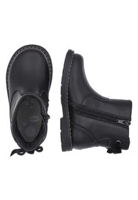 Botas de cuero negro hasta el tobillo con punta redonda, cremallera lateral y suela texturizada. Tacón bajo con costuras decorativas y tira en la parte trasera.
