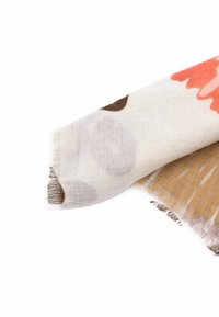 Sciarpa di cotone con un motivo floreale in toni di corallo, marrone e beige, con orli sfrangiati e una texture leggera e morbida.