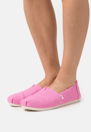 Pink slip-on shoes made of woven fabric with a textured finish, featuring a rounded toe and contrasting light sole.