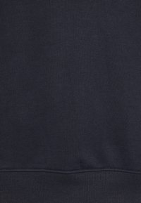 Sudadera de algodón azul marino con textura suave, puños y cintura acanalados. La tela es suave y uniforme, sin estampados.