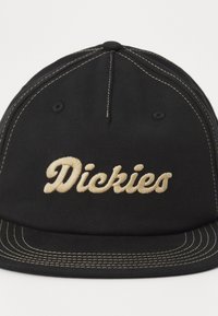 Fekete sapka bézs hímzett "Dickies" logóval. Görbített csúcsa, varrott részletezése és strukturált formája van.