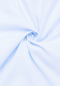 Tessuto azzurro chiaro con una texture liscia, caratterizzato da una leggera lucentezza e da un motivo intrecciato morbido. Il materiale è raccolto a forma di spirale.
