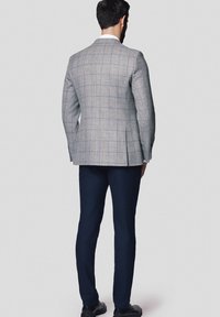 Szary marynarka w kratę z niebieskimi akcentami, texturedny materiał, dopasowany krój, w połączeniu z granatowymi spodniami i czarnymi butami, widok z tyłu.