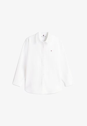 Valge puuvillane nööpidega särk, millel on klassikaline krae ja pikad varrukad. Vasakul rinnal on väike logo. Sile tekstuur.
