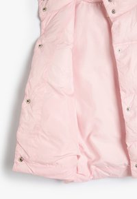 Rosa Puffermantel mit einer glatten, glänzenden Außenseite, silbernen Druckknöpfen entlang der Vorderseite und einem weichen Innenfutter.