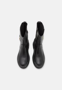 Black leather ankle boots with a smooth finish, elastic side panels, a zipper closure, and a textured rubber sole. Gold accent detail included.