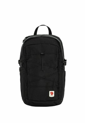 Sac à dos noir avec cordon élastique à l'avant, poches latérales, poignée supérieure et petite étiquette logo rouge en bas à l'avant.