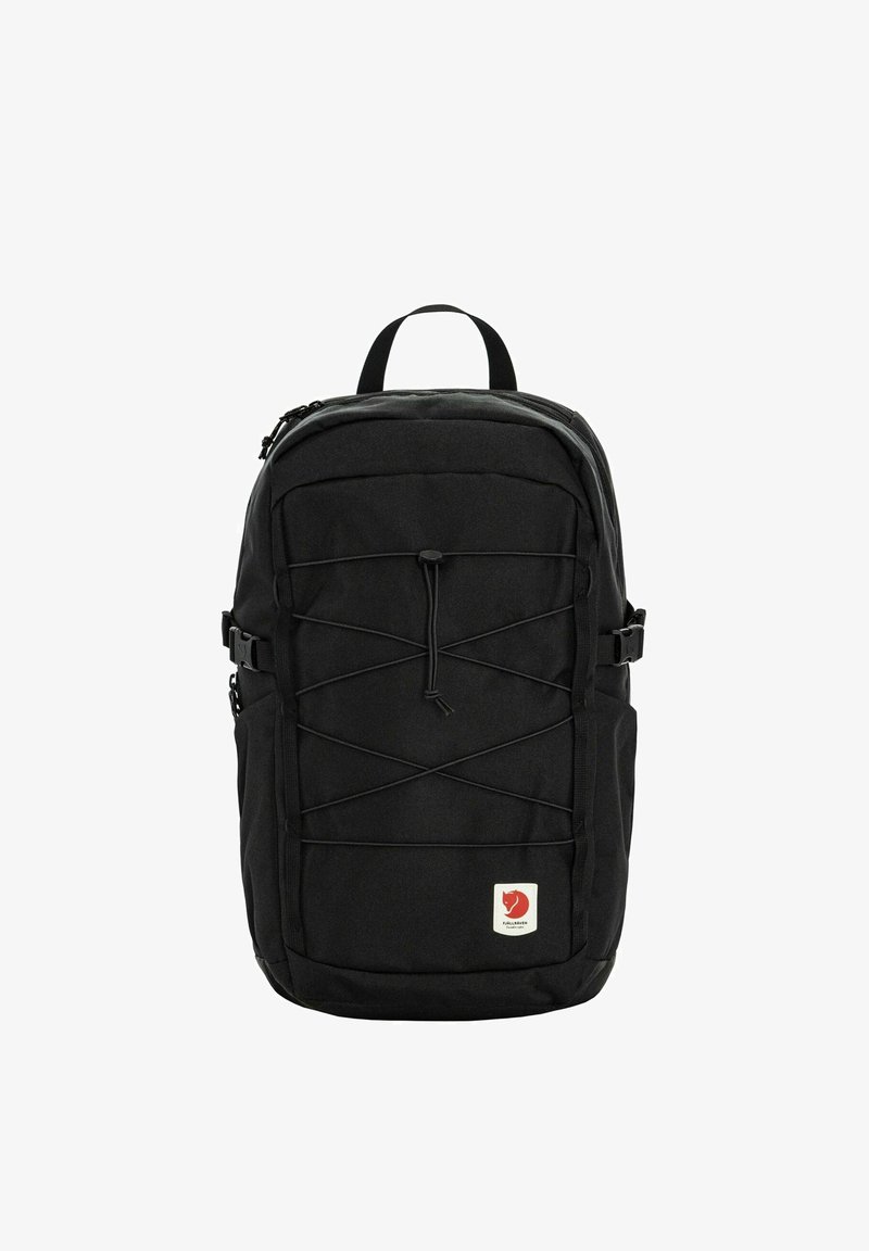 Sac à dos noir avec cordon élastique à l'avant, poches latérales, poignée supérieure et petite étiquette logo rouge en bas à l'avant.
