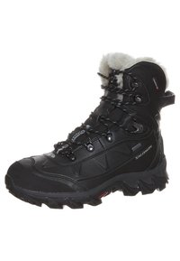 Bota de senderismo impermeable negra con un cuello forrado de pelo, suela resistente y puntera reforzada. Presenta ojales de metal y una superficie texturizada.