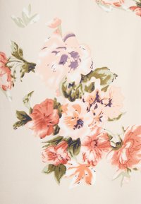 Tecido com estampado floral apresentando grandes flores rosas e laranjas com detalhes verdes sobre um fundo bege, textura suave e acabamento macio.