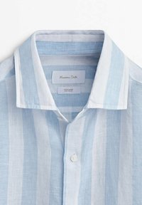 Chemise en lin à rayures verticales bleu clair et blanc avec col et bouton, étiquette Massimo Dutti visible à l'intérieur de l'encolure.